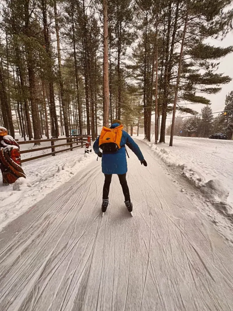 Personne patinant sur un sentier enneigé en forêt