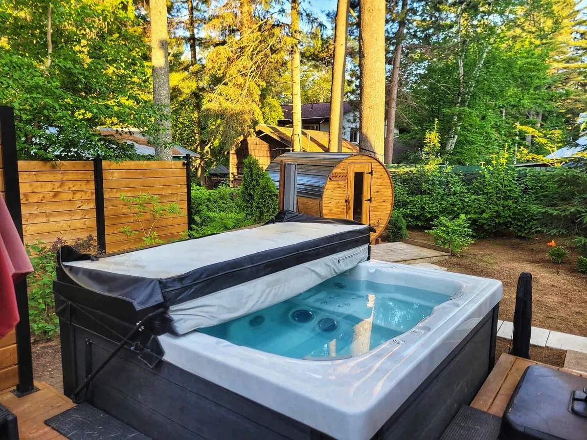 Spa et sauna tonneau dans la cour boisée